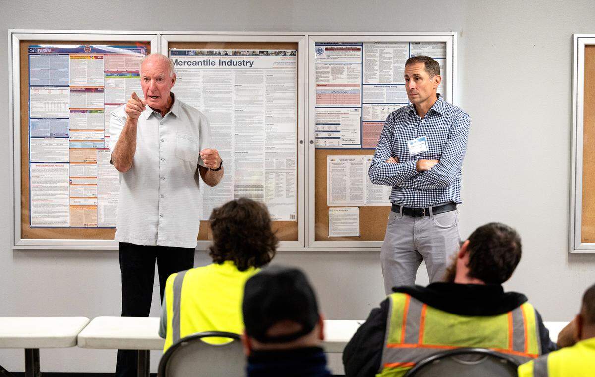 MTC Distributing owner Tom Eakin addresses his teammembers with new owner Justin Erickson, CEO of Harbor Foods in Modesto, Calif., Tuesday, Oct. 25, 2022.