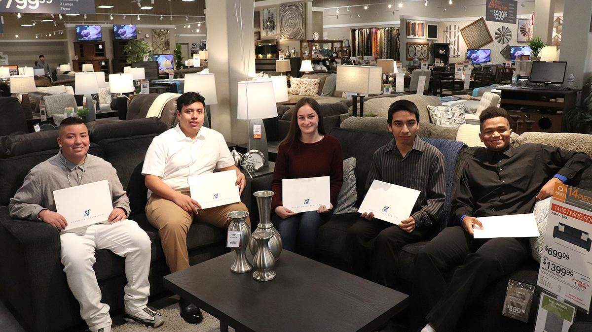 Aspiranet Transitional Aged Youth relax on a sofa and loveseat being donated from Ashley HomeStore in Modesto, Calif. Pictured are former foster youth Anthony, Bryan, Skyla, Jordan and Terence.