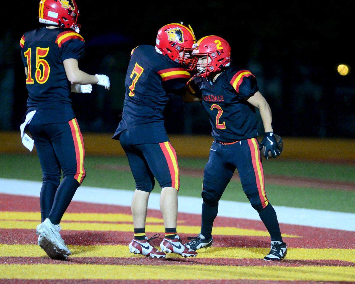 Oakdale running back Richard Flores (2) celebrates a touchdown with teammate Ricky Torrez (7) during a 2024 CIF Sac-Joaquin Section Division 3 playoff game between Oakdale High School and Destiny Christian Academy at Oakdale High School in Oakdale California on November 22, 2024. Oakdale won the game 49-35.