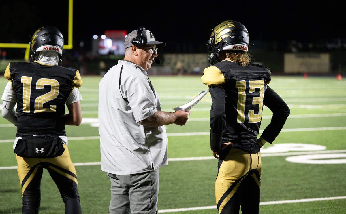 Enochs head coach Tracey Traub talks with quarterback Jakob “Slim” Hilterbrand during the non-league game with Buhach Colony at Gregori High School in Modesto, Calif., Friday, Sept. 1, 2023.