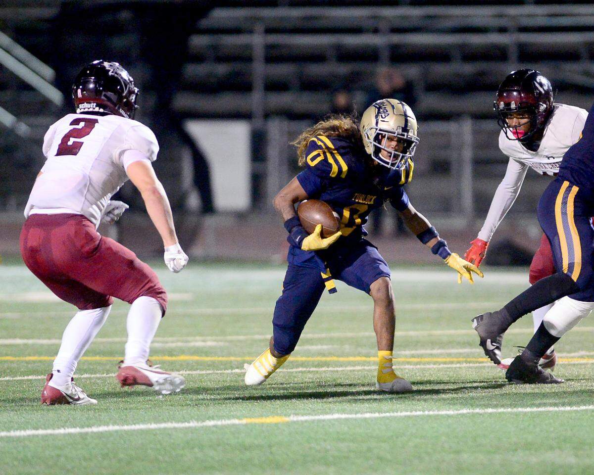 Turlock running back Jeremiah Stine (0) runs through an opening during a Division 1 CIF San-Joaquin Section playoff game between Turlock High School and Laguna Creek High School at Turlock High School in Turlock California on November 8, 2024. Turlock won the game 48-12.