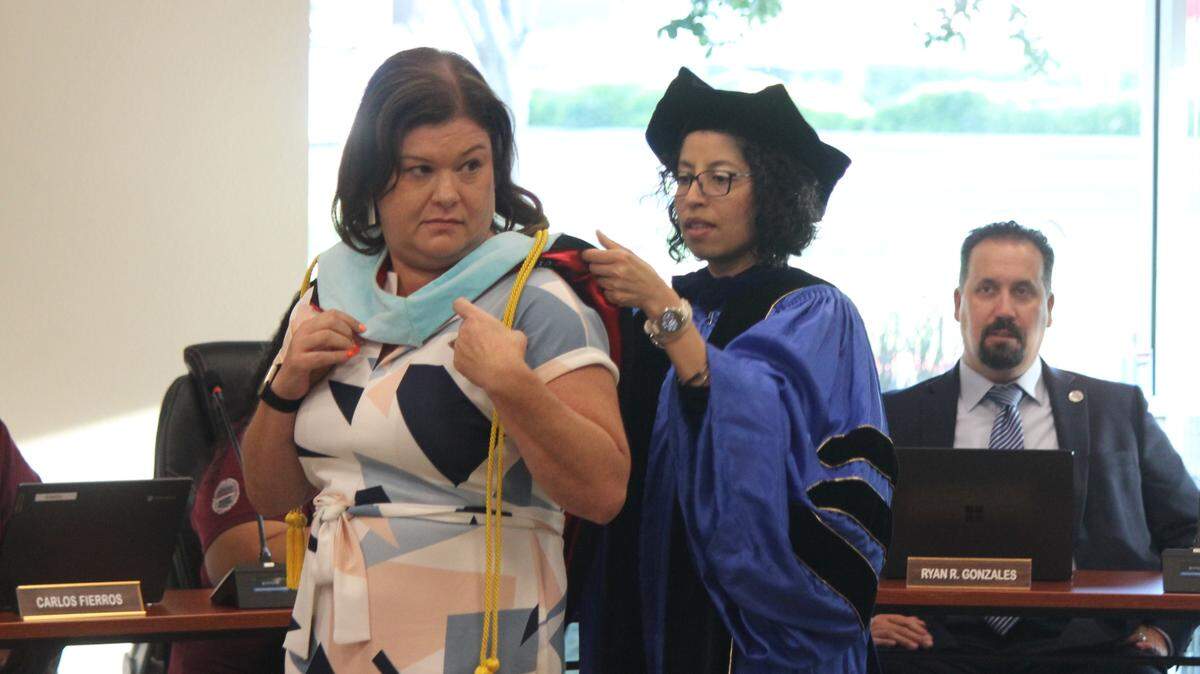 Stanislaus State Professor and Program Director Virginia Montero Hernandez (right) puts a stole around Corrin Rivera (right) during the special meeting on June 16, 2025.