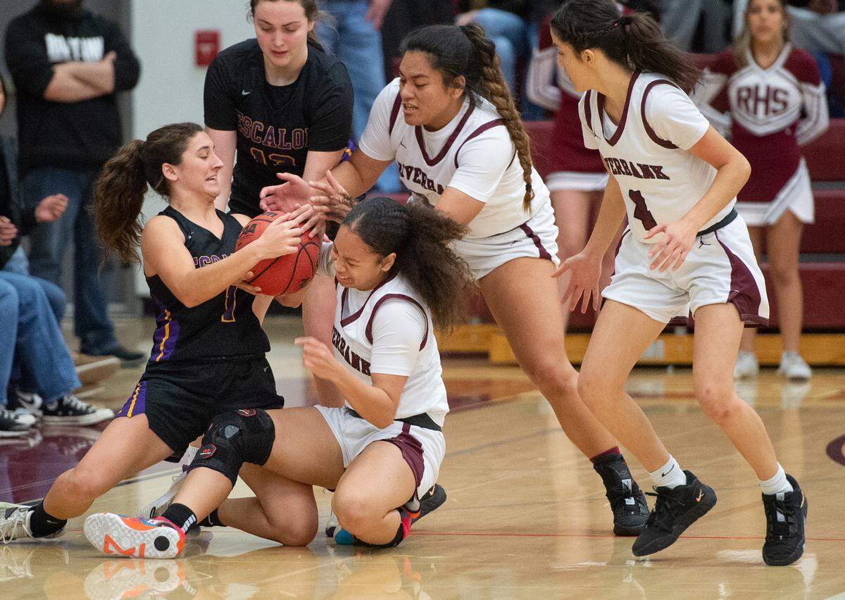 Escalon’s Sammy Lang (1) and Riverbank players Simone Mol, Rayne Tago, fight for a loose ball during the Sac-Joaquin section semifinal playoff game in Riverbank, Calif., Tuesday, Feb. 21, 2023. The Riverbank girls basketball team advanced to play Colfax in the Division IV section final after beating TVL rival Escalon 58-41 in the semifinals.
