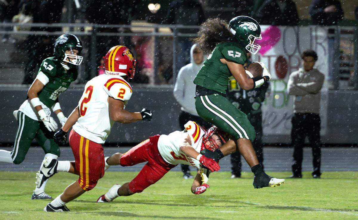 Manteca’s Maava Tialavea slips past Oakdale defenders on a touchdown run during the Valley Oak League game at Manteca High School in Manteca, Friday, Nov. 1, 2024.
