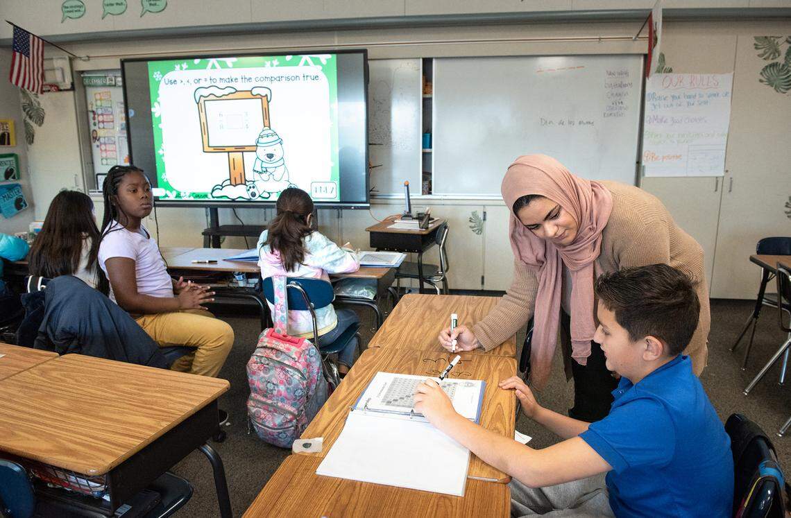 Fourth grade teacher Heba Morad helps Daniel Olide with a math problem during class at Walter White Elementary School in Ceres, Calif., Wednesday, Dec. 14, 2022.