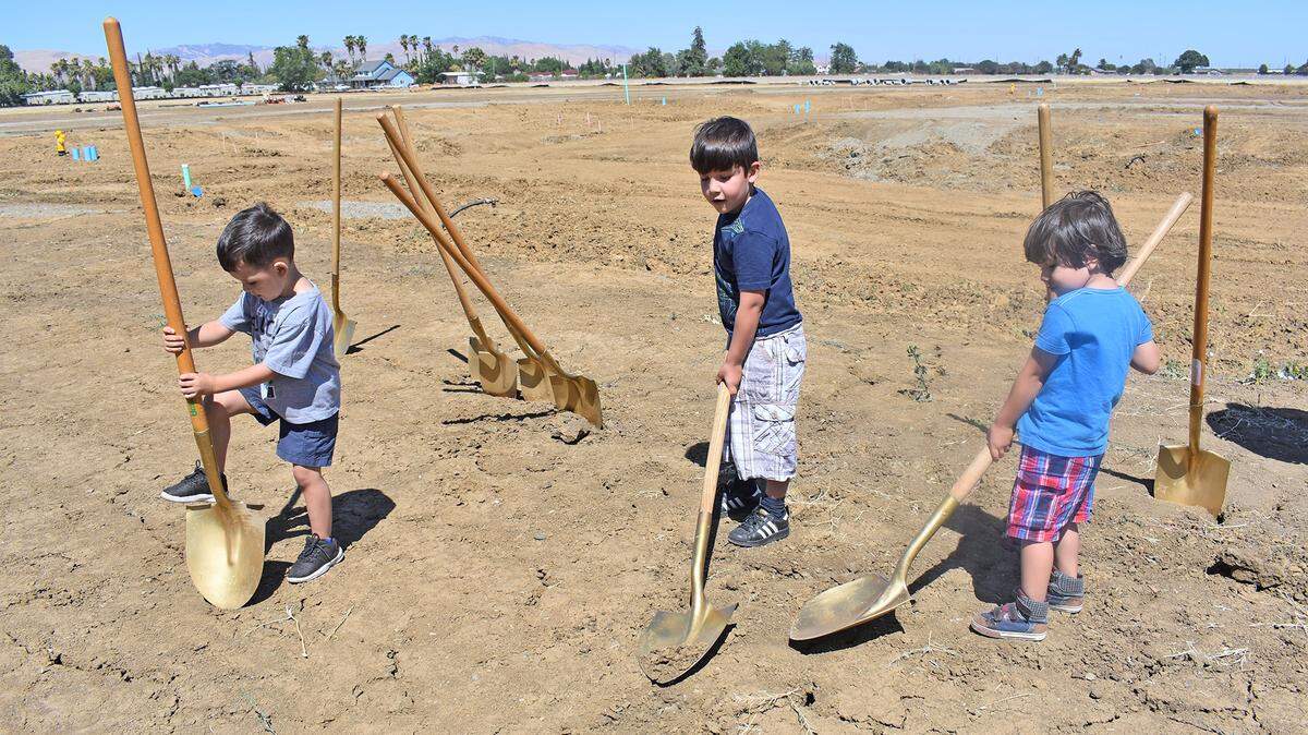 Children whose families are applying to be part of Self-Help Enterprises' Stonegate Shire subdivision at Walnut Avenue and North First Street in Patterson, Calif. play with shovels after the ceremonial groundbreaking Friday, June 29, 2018.