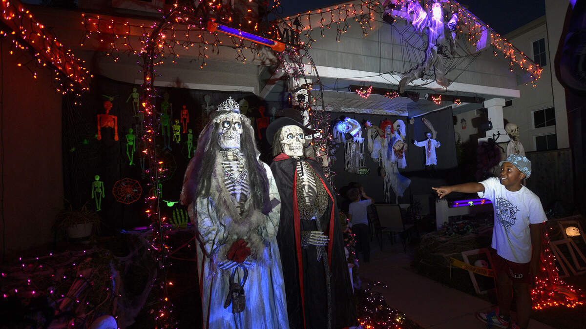In October 2013, neighbor Addie Mettler, then 8, points to bride and groom skeletons at the Halloween display at the home of Stephanie Valgos in Turlock.