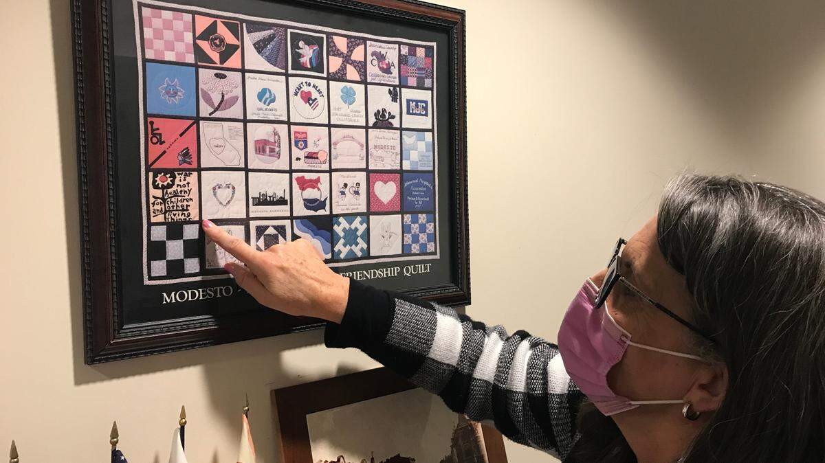 Using fabric gathered when Ukraine delegations visited Modesto, a Khmelnytskyi resident years ago crafted a “Modesto-Khmelnytskyi Friendship Quilt” into framed artwork now on display in a City Hall corridor in Modesto, Calif. Modesto Mayor Sue Zwahlen points to a square reading “War is not healthy for children and other living things.” Monday, Feb. 28, 2022.
