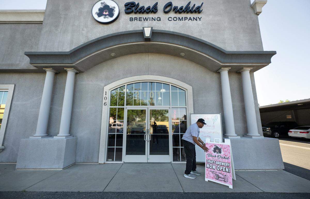 Joffre Roberts II, father of brewer Joffre Roberts, puts out a sign at the “soft” opening day at Black Orchid Brewing Company in Modesto, Calif., Friday, May 3, 2024.