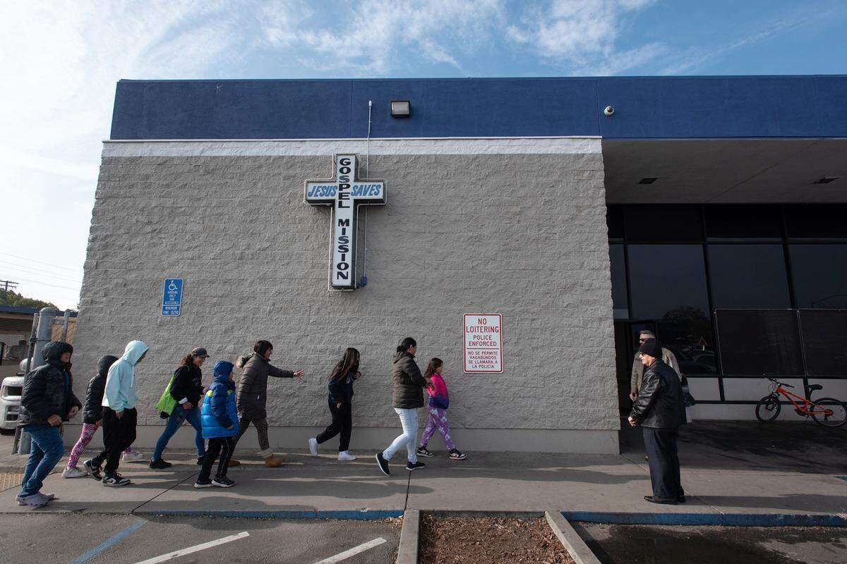 Guests arrive for Modesto Gospel Mission’s annual Christmas gathering in Modesto, Calif., Friday, Dec. 23, 2022.