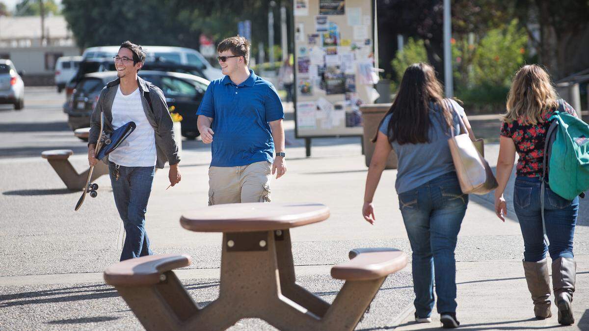 Julian Medrano, left, and Robert Briggs, middle, leave campus during an unseasonably warm day at Modesto Junior College in Modesto, Calif., on Thursday, Sept. 27, 2018.
