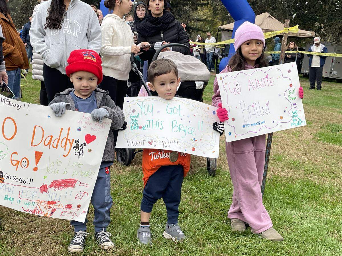 Vincent Clack, middle, joins his cousins Jordan and Jayleen Clack in cheering on family members at the Turkey Trot on Nov. 27, 2025, in Modesto, Calif. It is held each Thanksgiving morning in Tuolumne River Regional Park.