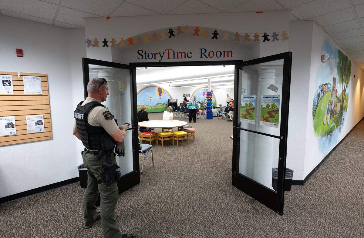 A Sheriff’s deputy stands outside the story time room during Rainbow Story Time at the Stanislaus County Library in Salida, Calif., Thursday, June 15, 2023.