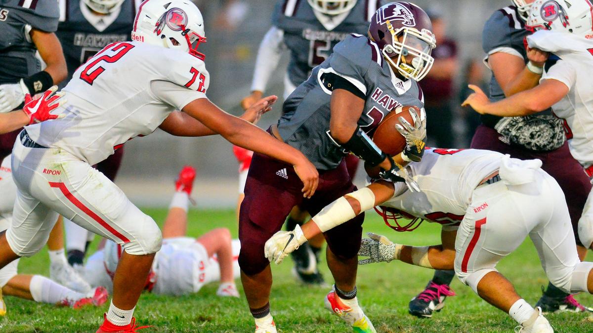 Central Valley running back Isaiah Hidalgo runs through two Ripon defenders during a game between Ripon High School and Central Valley High School at Ceres High School in Ceres California on September 6, 2019.