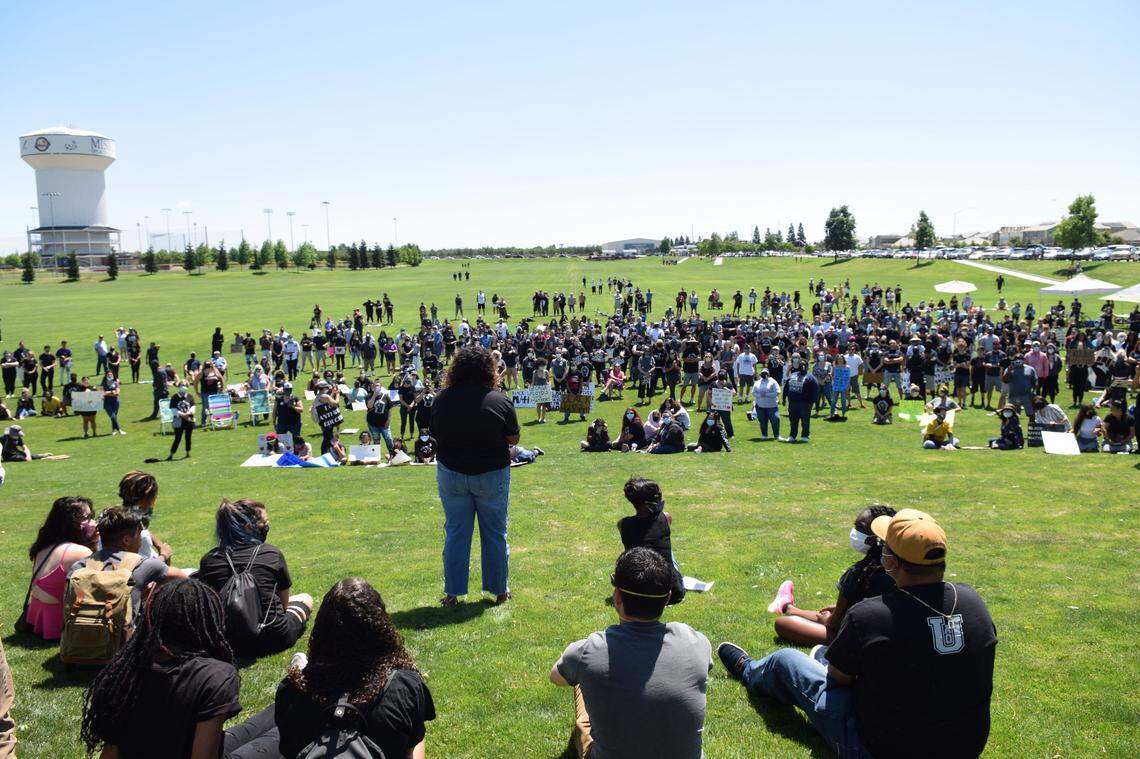 Bystanders listen to Malia Taylor (center left) speak during a protest at Mistlin Sports Park in Ripon, California on Saturday, June 6, 2020.