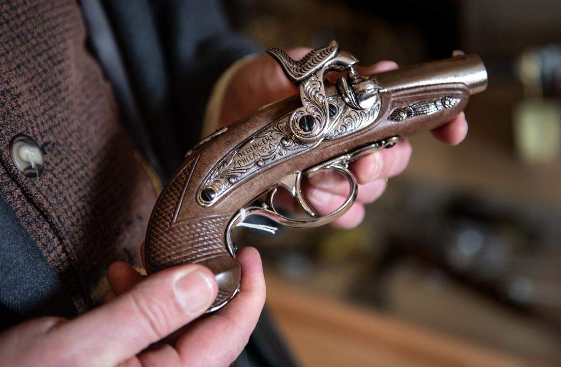 Columbia Booksellers and Variety Store owner Michael Sharps holds a non-firing replica Deringer flint-lock pistol at his store in Columbia, Calif., on Friday, Jan. 22, 2021. The Columbia State Historic Park shop was forced to close after its point-of-sale account was canceled by San Francisco tech service Square over replica guns.