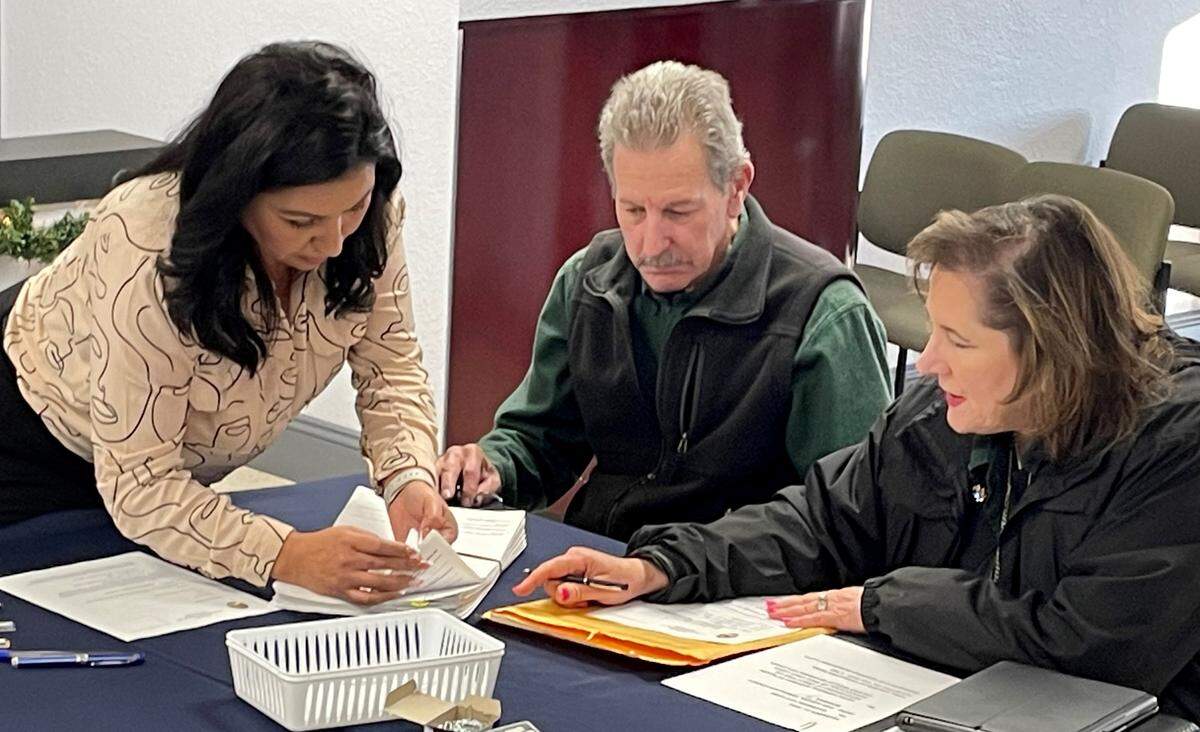 La secretaria municipal Gabriela Hernández, a la izquierda, recibió una petición para una medida electoral sobre el crecimiento en Riverbank, California, el 11 de diciembre de 2023. Los copatrocinadores Barney y Jami Aggers la entregaron.