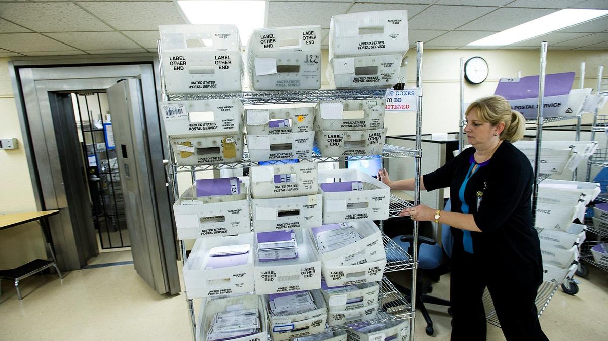Stanislaus County Registrar of Voters Donna Linder wheels a cart of sorted ballots that are to be flattened before they are counted at the Stanislaus County Clerks Recorder’s office in Modesto, Calif.