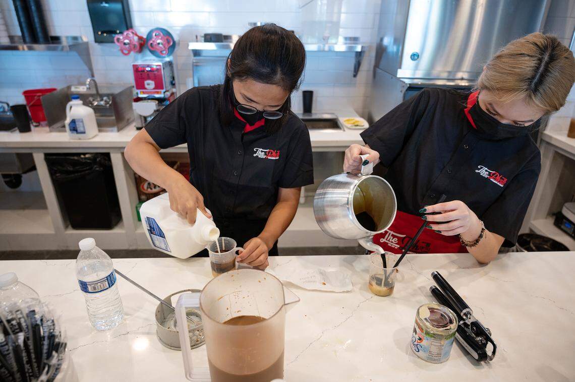 Servers Vy Phan, left, and Karen Bui, right, make Vietnamese coffee at The Pho restaurant in Modesto, Calif., on Wednesday, June 9, 2021.