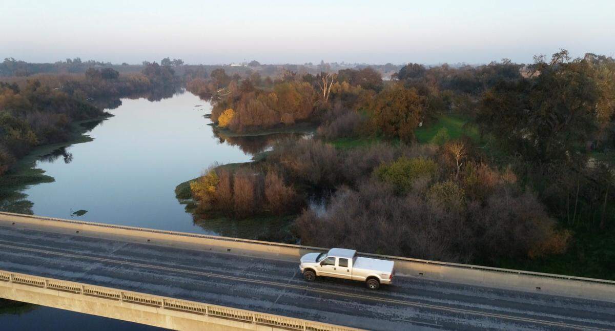 The Tuolumne River passes under the Deer Road bridge at Foxx Grove Park in Hughson, Calif., Dec. 1, 2021.