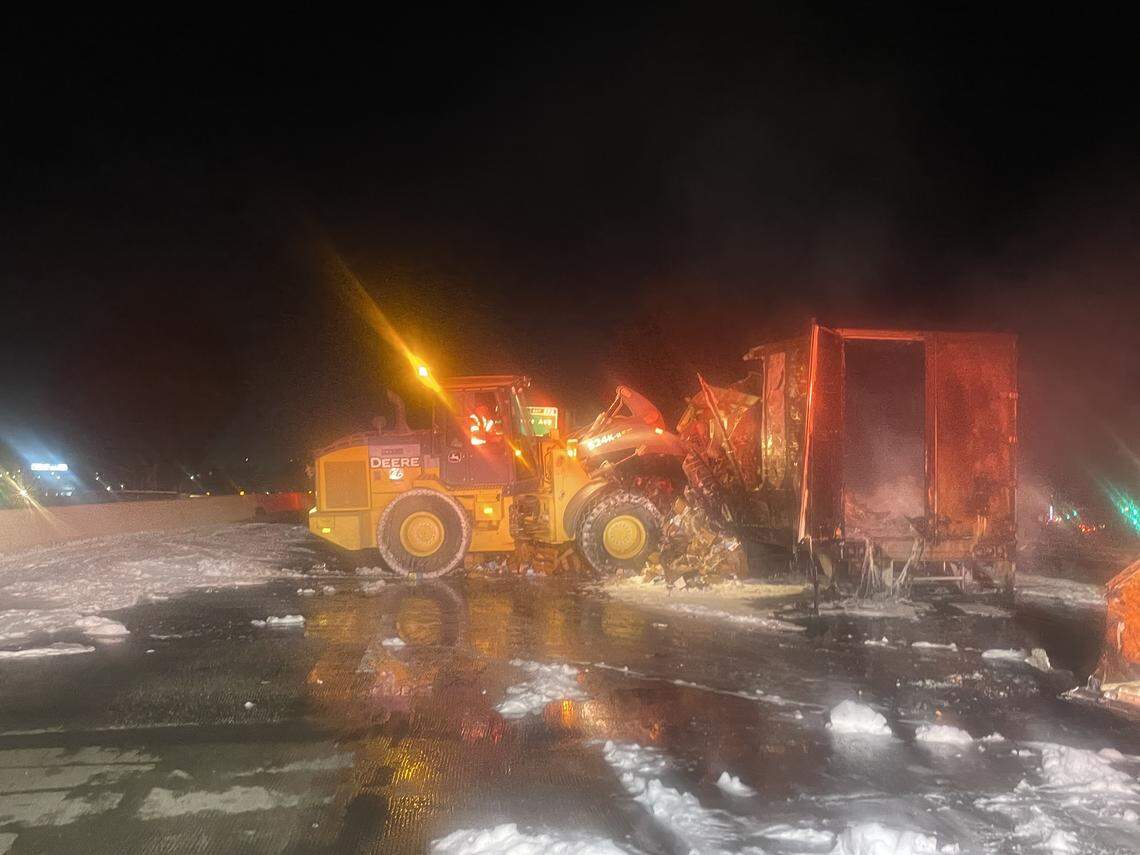 Heavy equipment is used to tear open a burned trailer on Highway 99 near Ceres so crews could remove its contents and extinguish remaining hot spots.