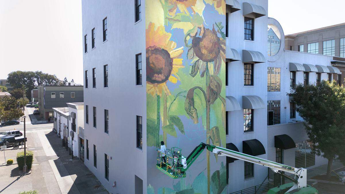 Artist Emily Ding works on a mural as part of the DoMo Walls mural festival in Modesto, Calif., Wednesday, Oct. 3, 2023.