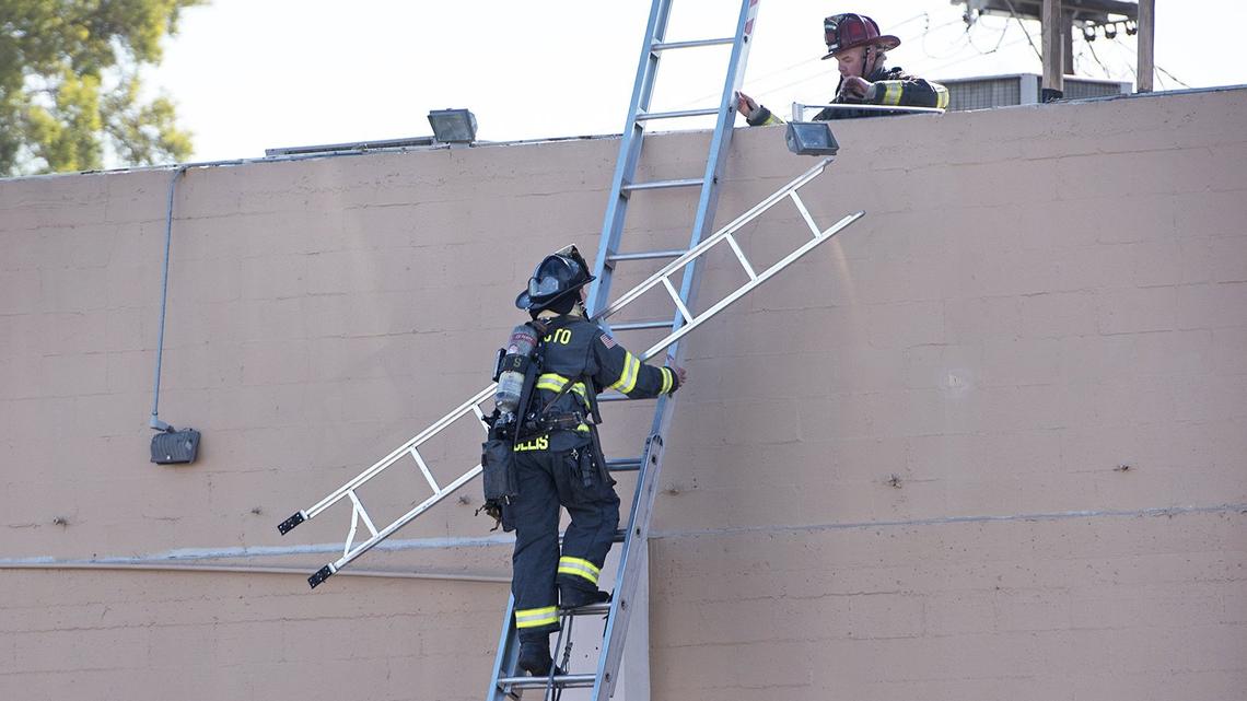 Modesto firefighters check the roof of a building on McHenry Avenue January 20, 2018.