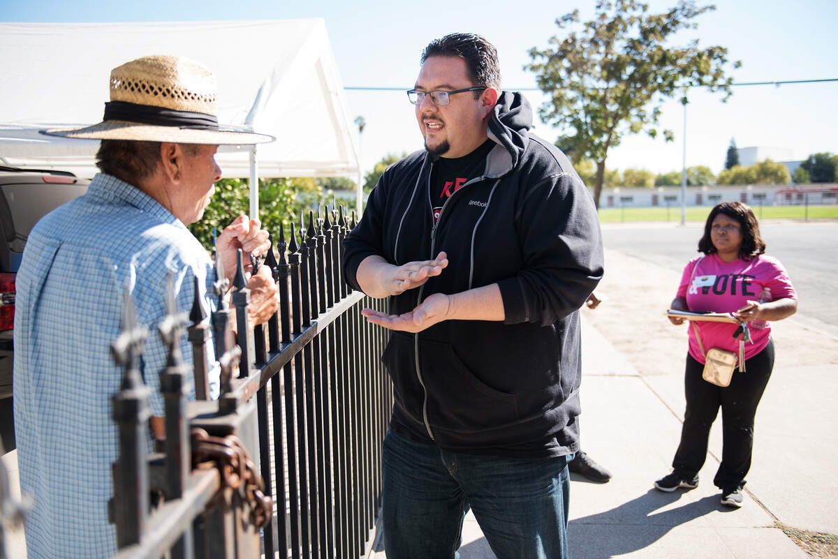 Political Director from PICO California, Eddie Carmona talks with a voter about proposition 10 as volunteers from Faith in the Valley canvas a neighborhood in advance of the November election in Modesto, Calif., on Saturday, Oct. 13, 2018. 