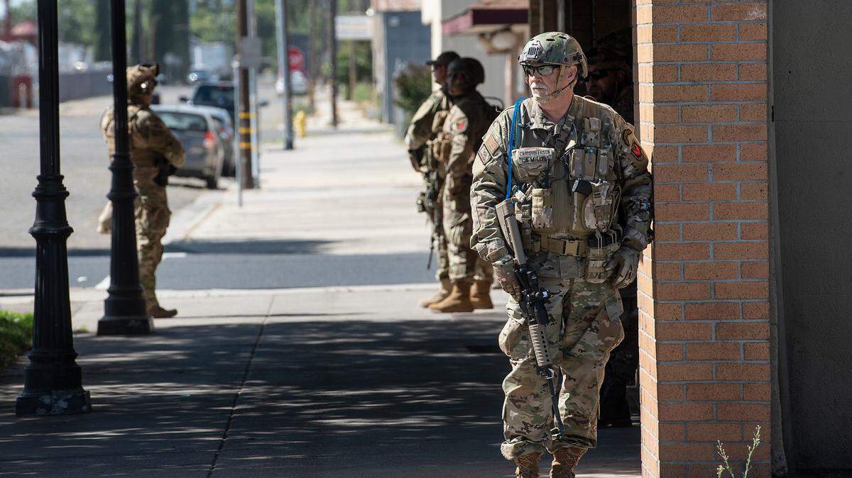 Members of the California State Militia stand outside the H-B Saloon on Highway 120 in Oakdale, Calif., on Saturday, June 6, 2020.