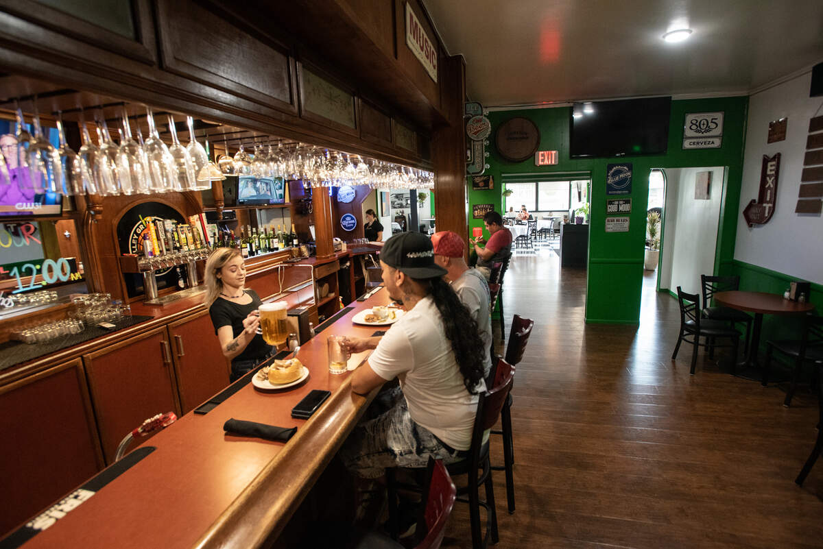 Manager Cherish Byrd serves beer to James and NaturalMac at Valley Grill on McHenry Avenue in Modesto, Calif., on Tuesday, Oct. 5, 2021.