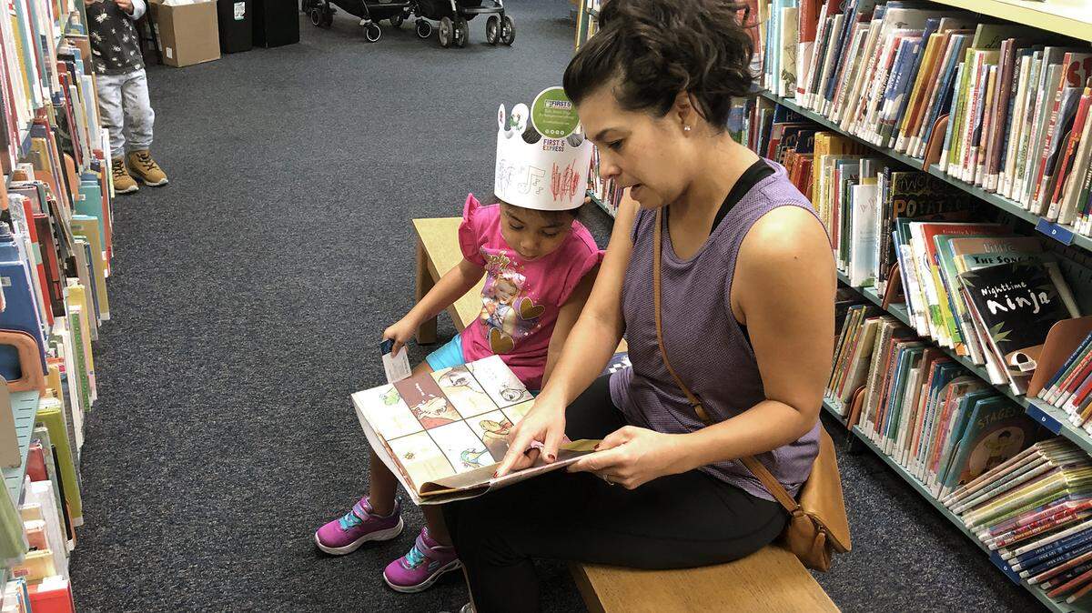 Claire Castro, 4yrs, and her mother, Valerie Castro, read together at the Stanislaus County Library in Modesto, Calif. on October 7, 2019