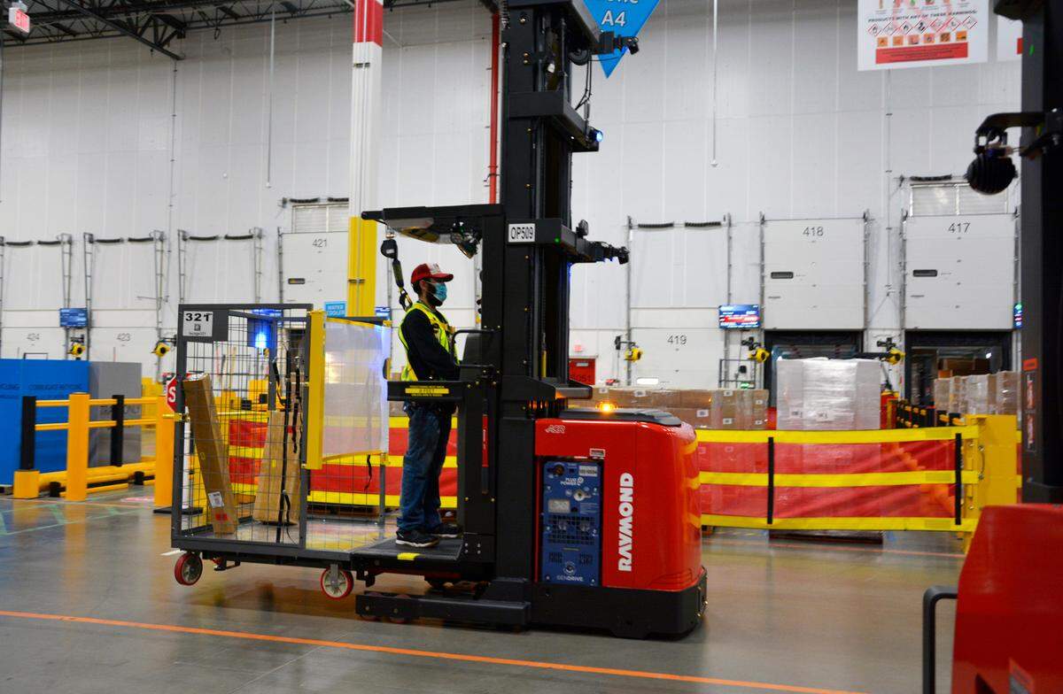 A worker drives a power lift inside the new Amazon fulfillment center that recently opened in Turlock, Calif Oct. 20, 2022.