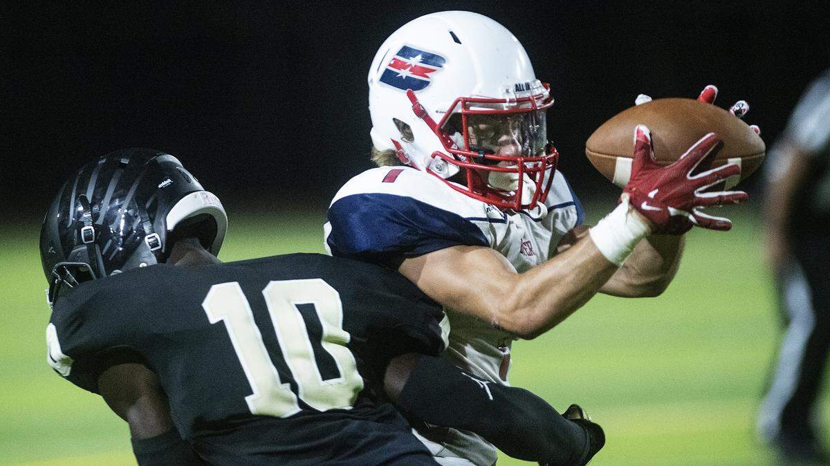 Beyer’s Blake Albino makes a catch as Enochs’ Aggee Tombe defends at Downey High School in Modesto, Calif., Friday, Aug. 23, 2019.