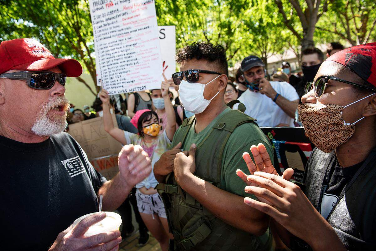 Black Lives Matter organizers Jaimee Ellison, right, and Elisha Coleman, middle, talk with a resident of Oakdale, left, during a protest in support of George Floyd in Oakdale, Calif., on Wednesday, June 3, 2020. Coleman and Ellison are co-founders of Turlock Black Lives Matter.