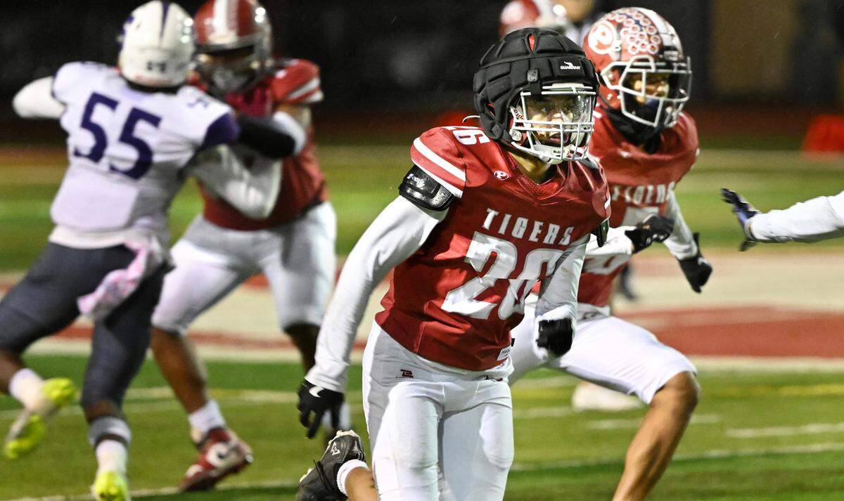 Patterson’s Romeo Manu (26) wears the Guardian Cap during the Sac-Joaquin Section Division IV semifinal game with Sacramento at Patterson High School in Patterson, Friday, Nov. 22, 2024.