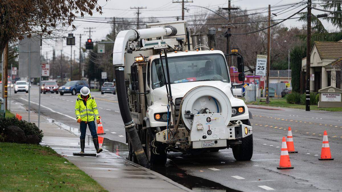 A City of Modesto crew works to clear backed up storm drains before the next wave of rain in Modesto, Calif., Thursday, Dec. 29, 2022.
