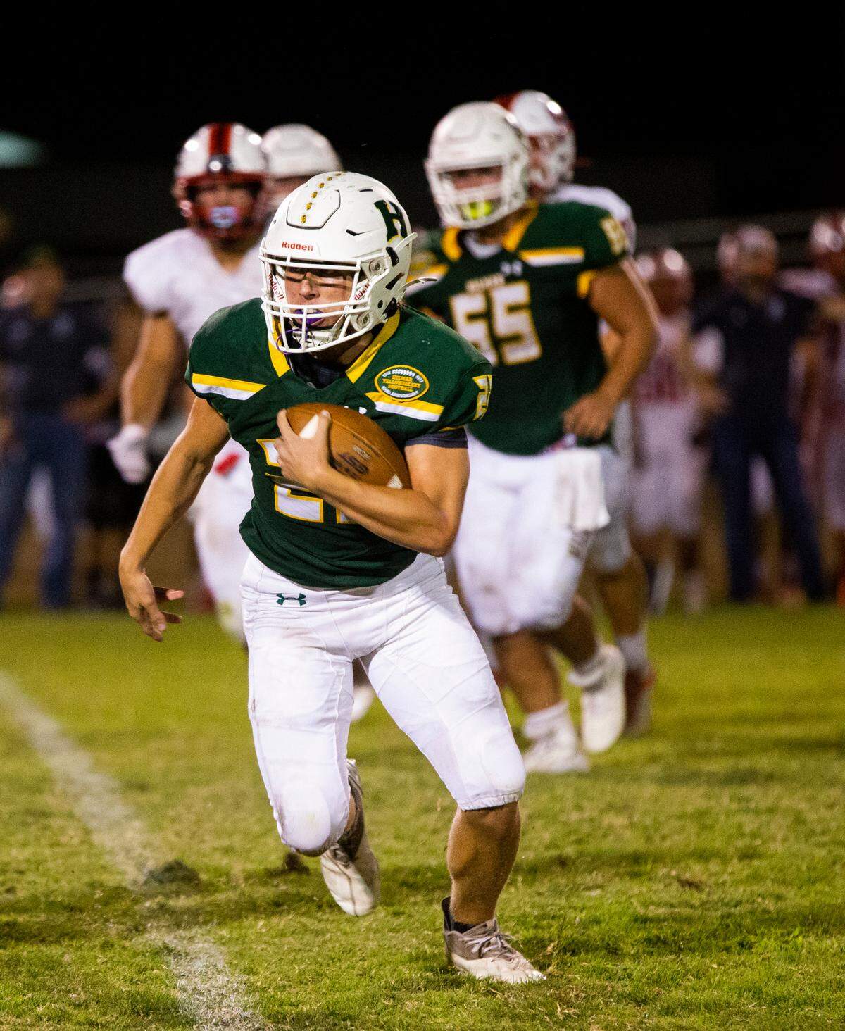 Caden Bailey, 22, of Hilmar High does a quarterback keeper. Ripon vs Hilmar at Hilmar Sept. 23, 2022.