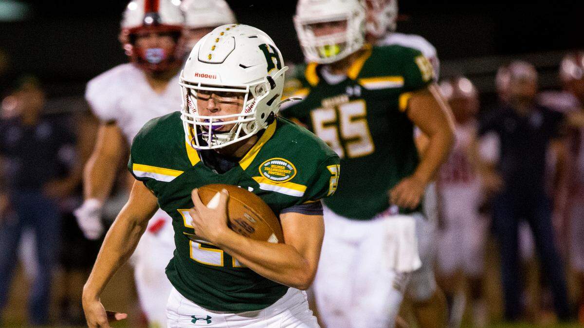 Caden Bailey, 22, of Hilmar High does a quarterback keeper. Ripon vs Hilmar at Hilmar Sept. 23, 2022.