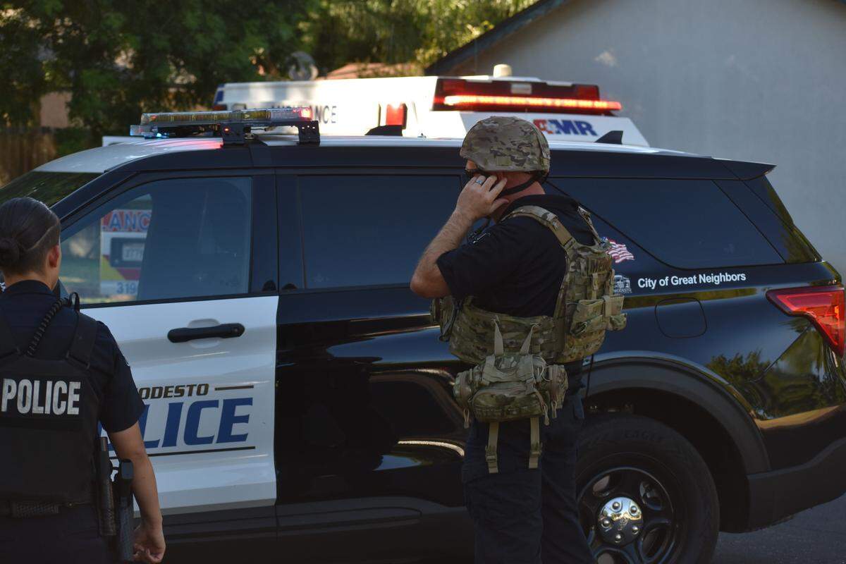 A member of the AMR Tactical Rescue Unit puts on his helmet Sunday afternoon after being directed to move inside the perimeter set up during the standoff Sunday.