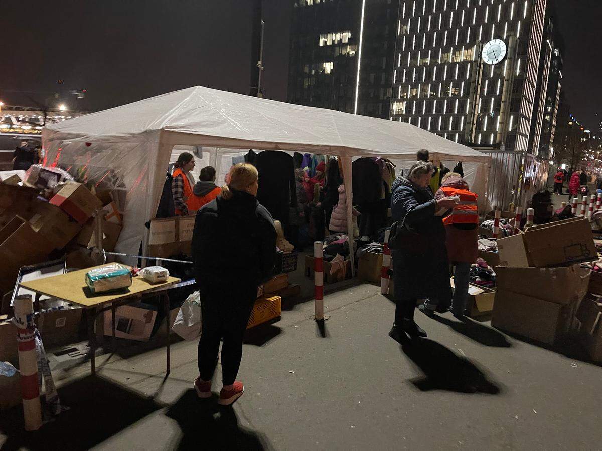People gather at night to collect food and clothes at an Aid Station in the Ukraine.