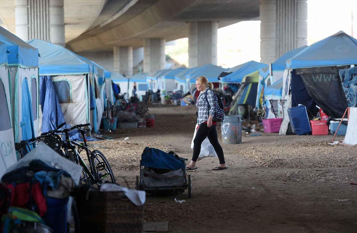 A resident walks through camp at the Modesto Outdoor Emergency Shelter in Modesto, Calif. on Monday November 11, 2019.