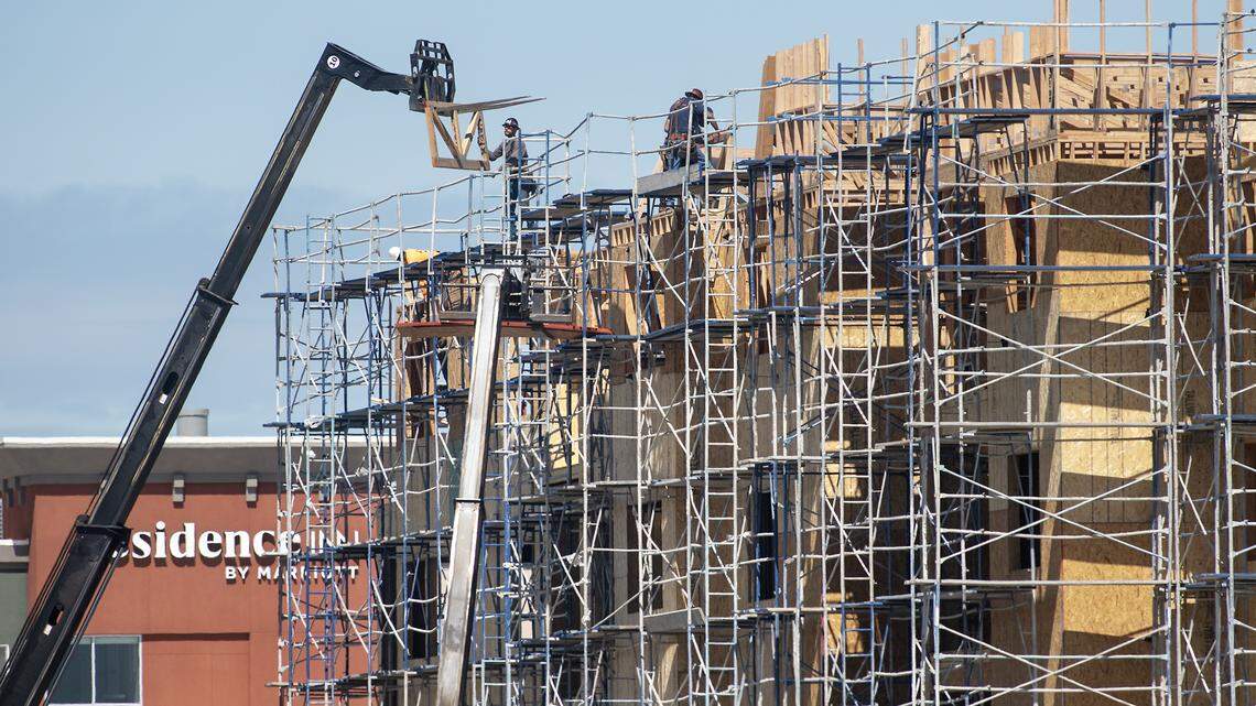Construction work continues on an apartment complex near Kaiser Hospital in Modesto, Calif., on Tuesday, March 31, 2020.
