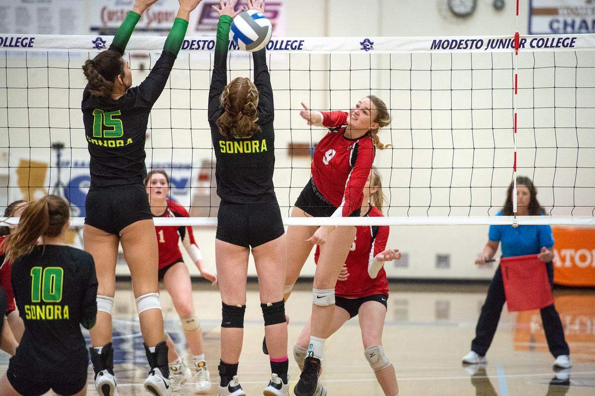 Ripon’s Kylee Fullmer (9) hits past Sonora’s Mia Alomia (15) and Pace Anderson during the Sac-Joaquin Section Division 4 Section final at Modesto Junior College in Modesto, Calif., Saturday, Nov. 5, 2022. Ripon won the title 3-1.