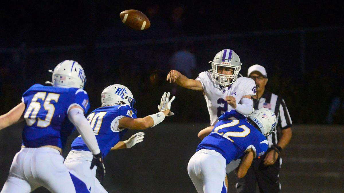 Denair quarterback Landen Borges thorws the ball as he is hit by RC defender Derek VanElderen (22) during a game between Ripon Christian and Denair at Ripon Christian High School in Ripon California on September 16, 2022.