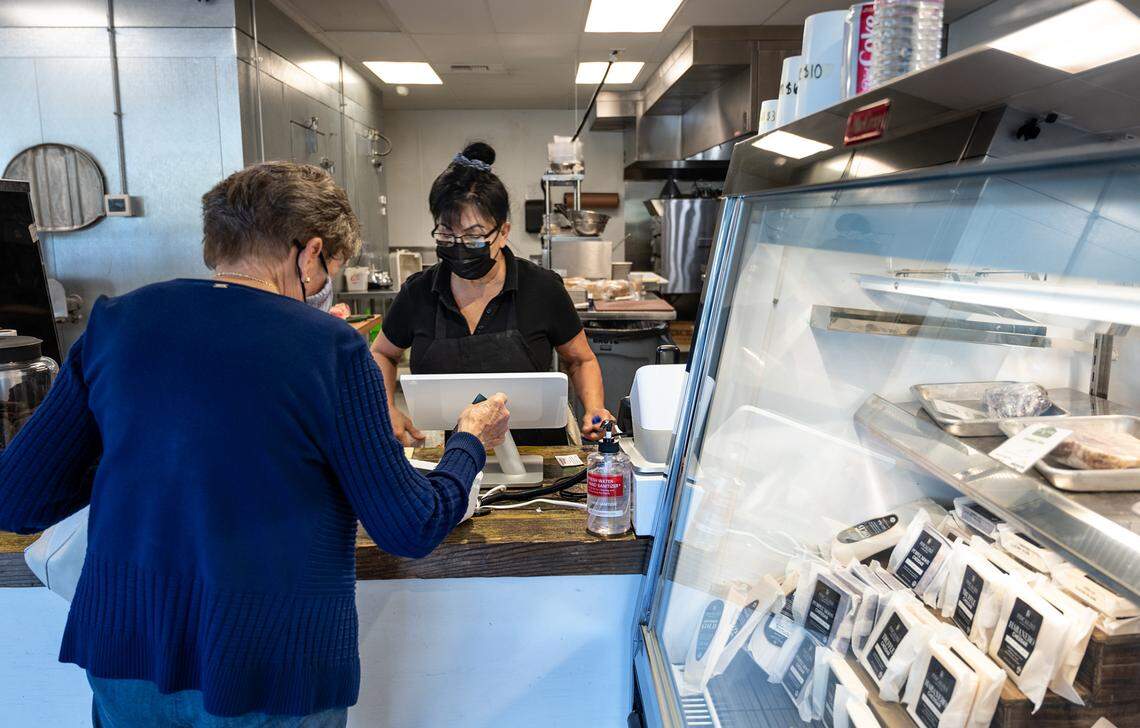 Trish Flanagan assists a customer at Village Butcher in Modesto, Calif., on Wednesday, May 19, 2021.