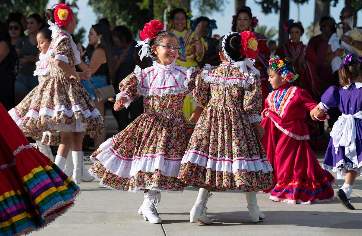 Anabella Plascencia, 7, left, and Zoe Urbina, 7, right, perform with other members of Westside Fiesta Mexicana Alas dance group during National Night Out at North Park in Patterson, Calif., Tuesday, Aug. 1, 2023.