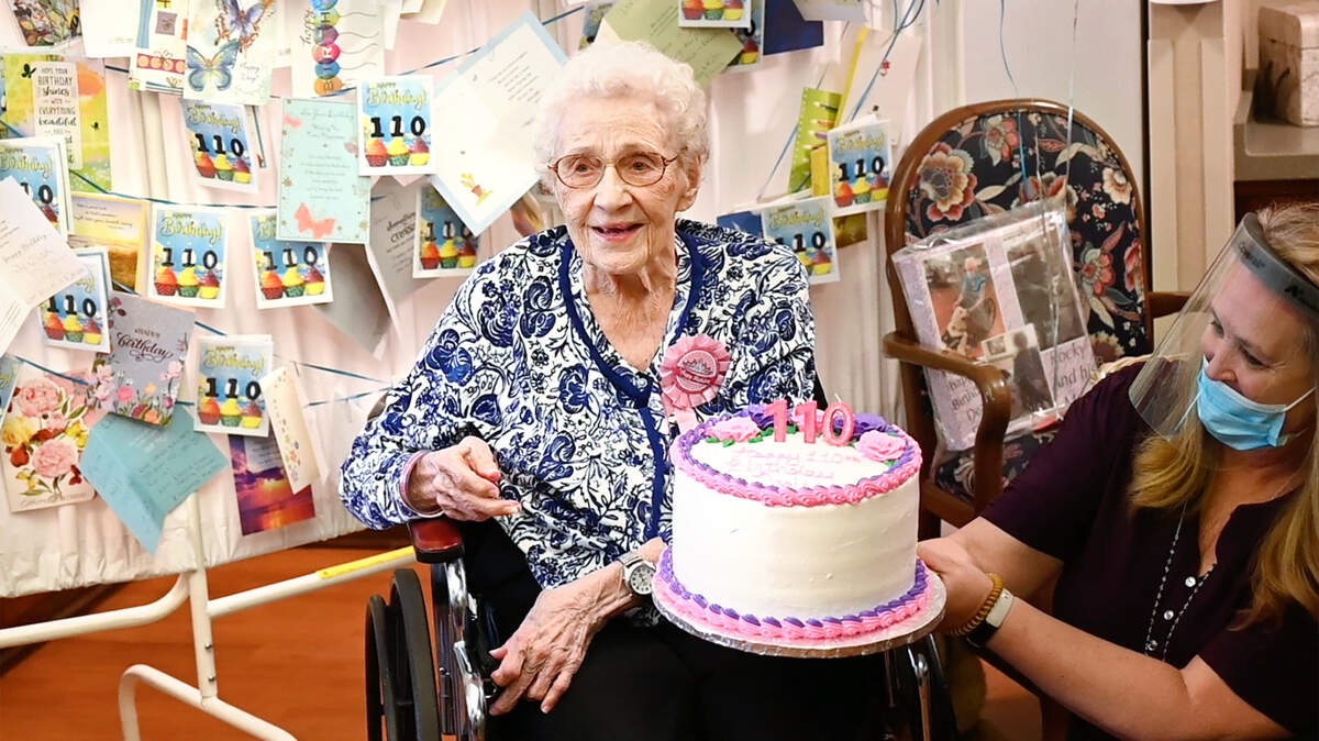 Activity director Denise French holds a birthday cake for Doris Johnson who is celebrating her 110th birthday at Covenant Living in Turlock Calif., on Friday, Nov. 5, 2021.