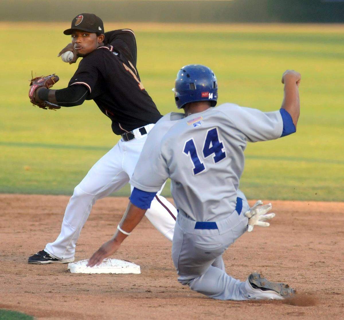 Angelys Nina of the Modesto Nuts winds up to make the double play at first after the out at 2nd of Michael Choice in game against the Stockton Ports, (7-22-11)