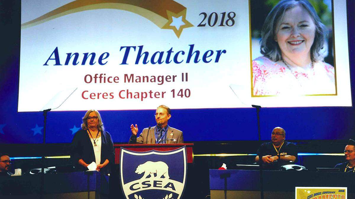 Supt. Scott Siegel of the Ceres, CA, Unified School District, center, speaks about Anne Thatcher, left, office manager at Blaker-Kinser Junior High School, at an award ceremony in Sacramento on Tuesday, July 31, 2018, Thatcher was one of five statewide winners of the Member of the Year award from the California School Employees Association.