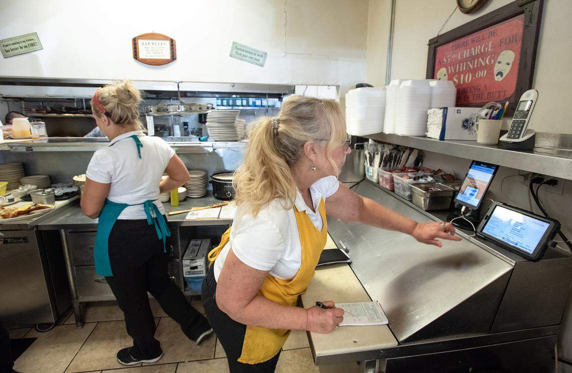 Shelia Wooley writes up food delivery orders at My Garden Cafe in Modesto, Calif., on Friday, May 13, 2022.